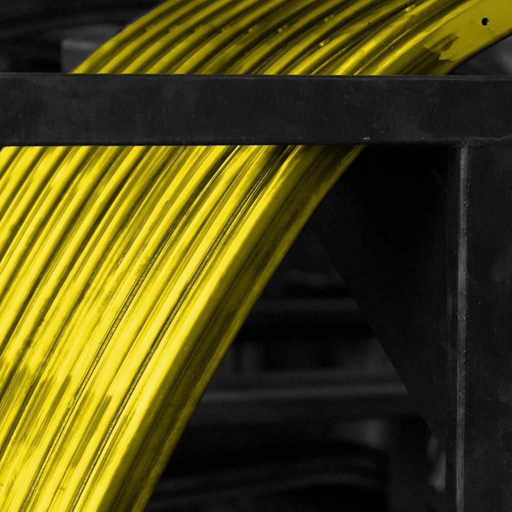 A spool of yellow wire on a black and white background.